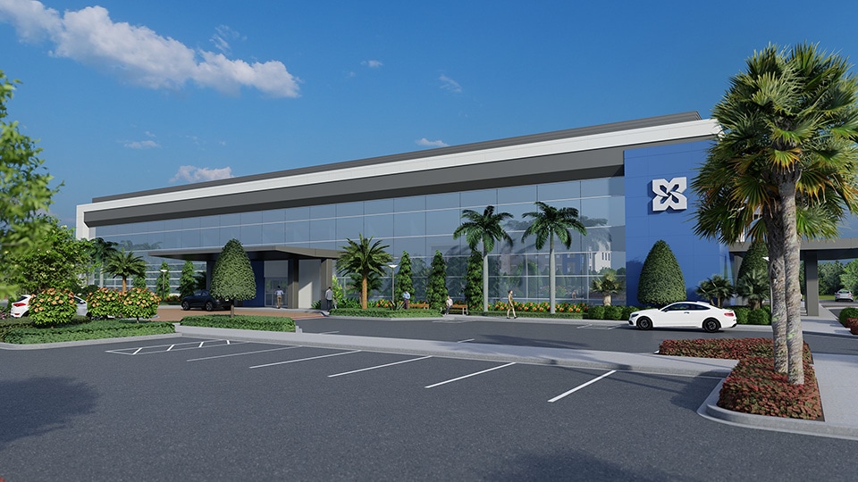 The blue exterior of the Avenir Health Park wit palm trees and a parking lot in front.